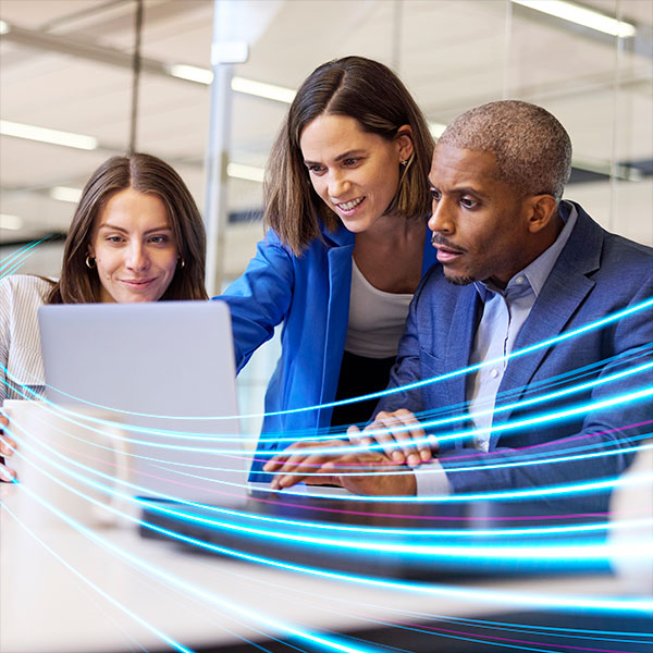 Three professionals look at a laptop together in an office setting, with blue digital light streaks added in the foreground.